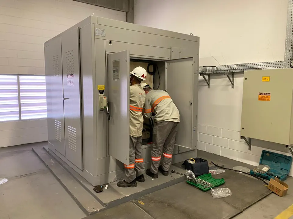 Equipe com EPIs realizando manutenção em cabine primária